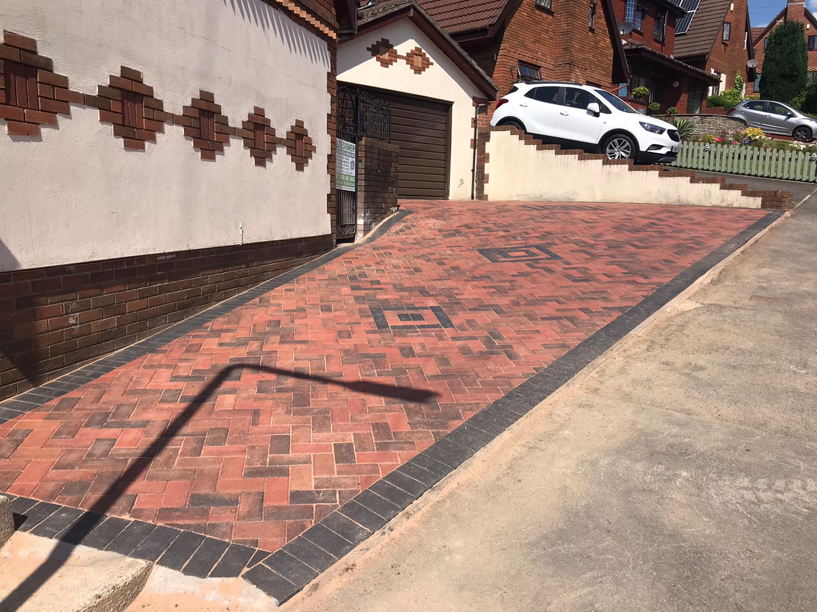 Red block paved driveway in Cardiff with a dark diamond and Greek key inlay pattern